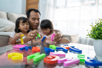 colorful alphabet toys useful to help his daughters to knows text when playing with father