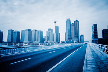 Fototapeta premium empty asphalt road on modern bridge with city skyline background.