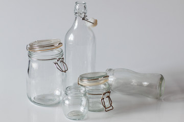 Empty glass bottles and jars on white background