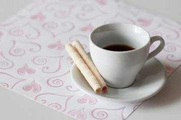 Breakfast. Black coffee in a Cup and wafer tubes