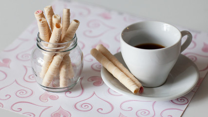 Breakfast. Black coffee in a Cup and wafer tubes
