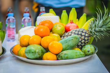 Set of fresh tropical fruits including banana, orange, pineapple, fresh water, red water, coconut, apple, mango, grape, longan, prepared for the spirits of the gods  worship ceremony