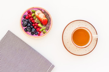 Healthy vegetarian breakfast. Acai smoothie bowl with fresh fruits, berries, chia seeds on white background top view