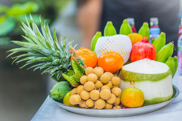 Set of fresh tropical fruits including banana, orange, pineapple, fresh water, red water, coconut, apple, mango, grape, longan, prepared for the spirits of the gods  worship ceremony