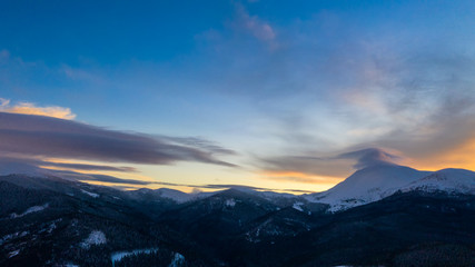 Naklejka na ściany i meble Beautiful winter sunrise in the mountains, shot from the air.