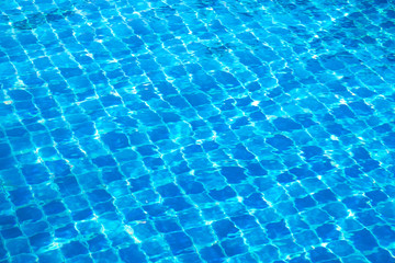 Blue abstract mosaic tiles at the bottom of the swimming pool, background.