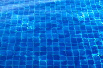 Blue abstract mosaic tiles at the bottom of the swimming pool, background.