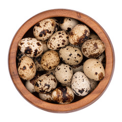 Quail eggs in a wooden bowl isolated on white background. 