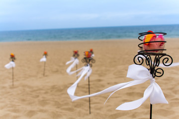 Flower lanterns with white ribbons ont he beach