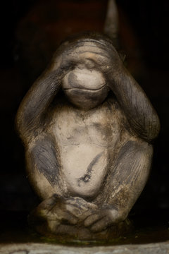 Monkey stone statue, not seeing on dark background
