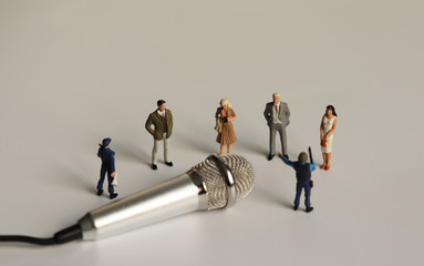 Miniature people gathered in front of the microphone.