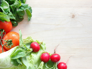 Fresh vegetables on a wooden board - radish, lettuce, arugula, tomatoes