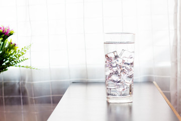 Glass of iced water on the table background