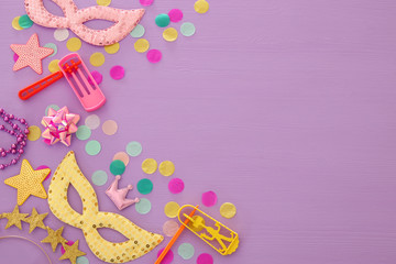 Purim celebration concept (jewish carnival holiday) over wooden pink background.