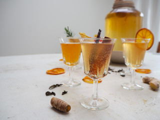 Multiple glasses with a variety of flavored kombucha tea such as cinnamon, citrus, turmeric and rosemary