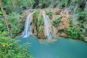 Fototapeta na wymiar Tard Sa Tor Waterfalls, beautiful blue-green water color around with green forest background, Mae Ping National Park, Li District, Lamphun, northern of Thailand.