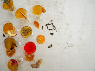 Multiple glasses with a variety of kombucha flavors on a white background