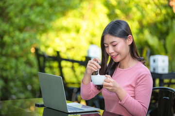 Women are selling products through social media using online notebooks at coffee shops.