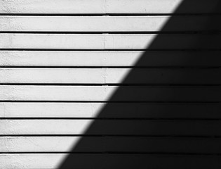 white wood battens wall with light and shadows. - monochrome