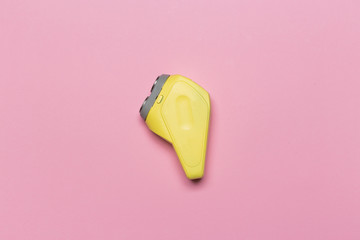 Antique electric razor. Old yellow shaver on pink background