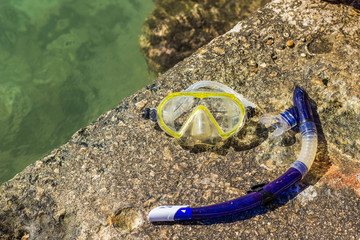 snorkeling mask and tube cheap equipment for summer sea hobby activities on sea stone shoreline 