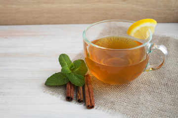 Mint,cinnamone and lemon tea on a white wood background