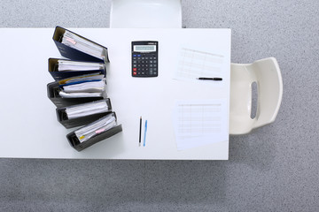 Binders with papers are waiting to be processed with bookkeeper. Internal Revenue Service inspector...