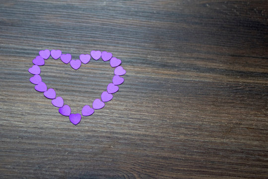 A purple heart on a dark wood background