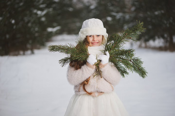 little happy beautiful girl in winter forest