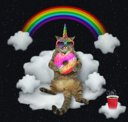 The cat unicorn in sunglasses with a color donut is sitting on the cloud like a divan. The cup of...
