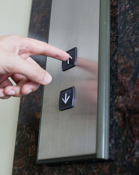 hand pressing elevator button up