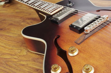 Fototapeta na wymiar Jazz guitar on a wooden textured background. Close-up