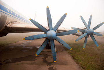  propellers of an old passenger plane in a hazy haze with blue frayed blades