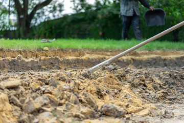 gardener digs the soil with his equipment for gardening and prepare land for plantation.