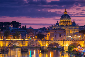 Fototapeta na wymiar Night view of old Sant' Angelo Bridge and St. Peter's cathedral in Vatican City Rome Italy.