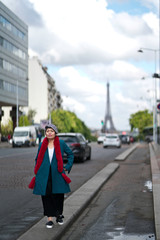 Naklejka premium Femme marchant dans la rue avec tour eiffel en arrière plan