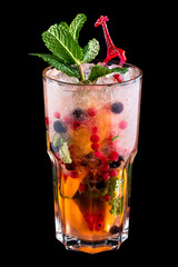 Lemonade with wild berries in a glass on a dark background. Drink for children.