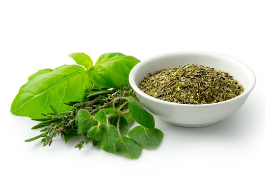 Dried Chopped Provence Herbs In A White Ceramic Bowl Next To Fresh Bouquet Garni Isolated On White.