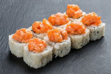 Sushi roll with salmon and cheese on black background