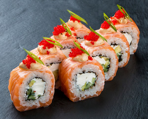 Sushi roll with salmon and Philadelphia cheese on black background