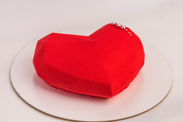 Cake in the shape of heart on Valentine's Day. Cake in the form of a red heart on white background.