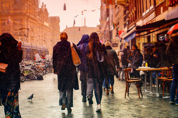 people on a city street during the rain - obrazy, fototapety, plakaty