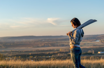Girl on a high mountain trains with a machete in the evening at sunset