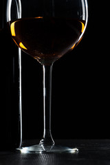  wine bottle and wine glass in a black background