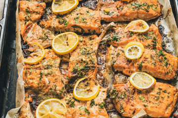 Pieces of salmon baked on a baking sheet, top view