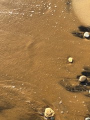 Wet wave over a sandy beach in Greece