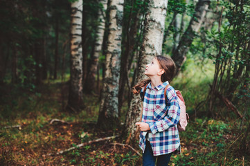 happy kid girl exploring summer forest, traveling on vacation. Teaching kids to love nature. Earth...