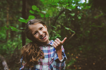 happy kid girl exploring summer forest, traveling on vacation. Teaching kids to love nature. Earth day concept.