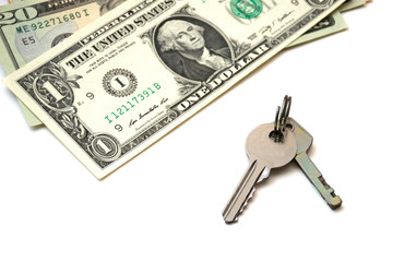Isolated metal keys and a bunch of banknotes of American dollars