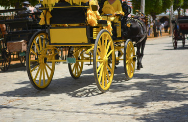 Fototapeta na wymiar a beautiful yellow carriage at the feria de Abril in Seville